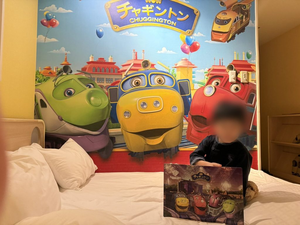 チャギントンのパズルを持ってベッドに座る子ども