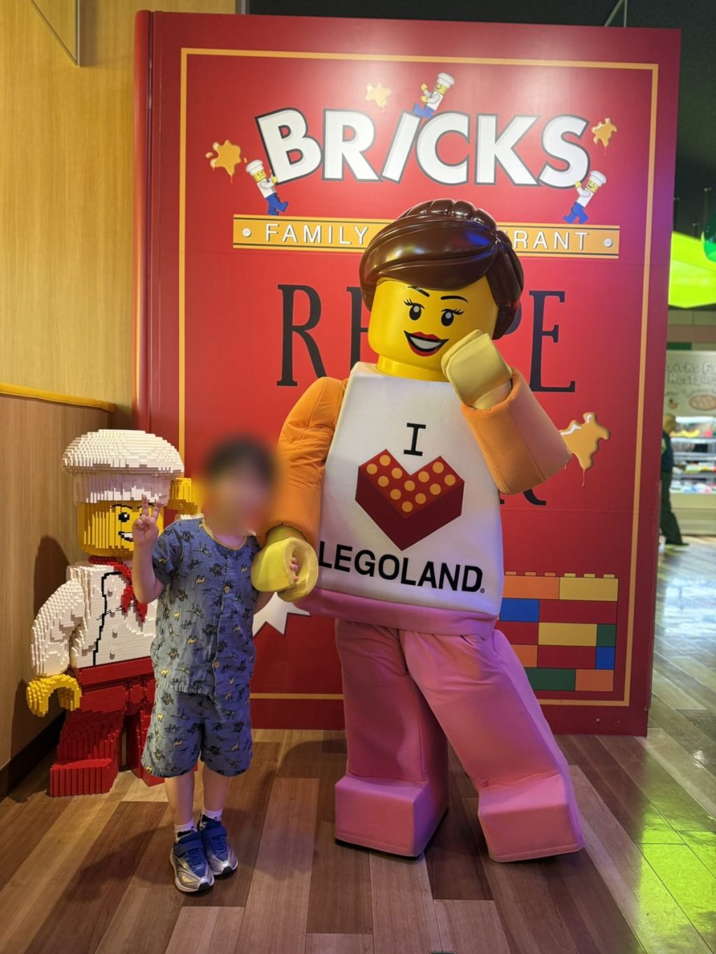 BRICKSファミリーレストランの前でキャラクターと写る子ども